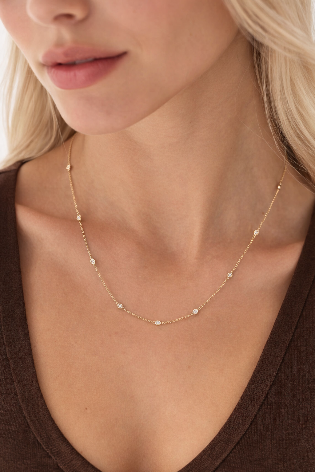 close-up image of ALVA Diamond Bezel Station Necklace in yellow gold on a model's neck 